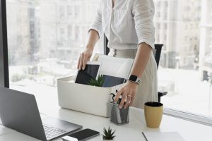 Side view woman packing desk items